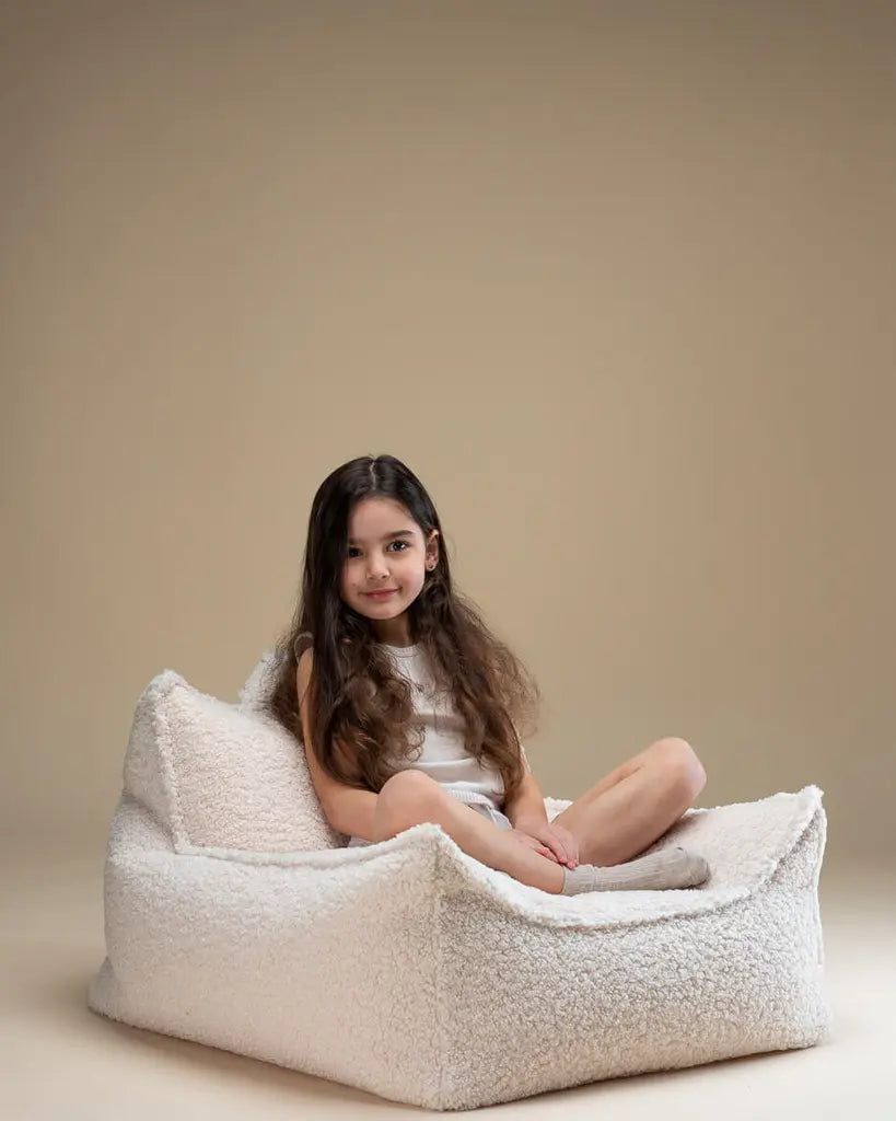 Wigiwama | Witte teddystof zitzak stoel waar een meisje op zit | Conceptstore Sisällä